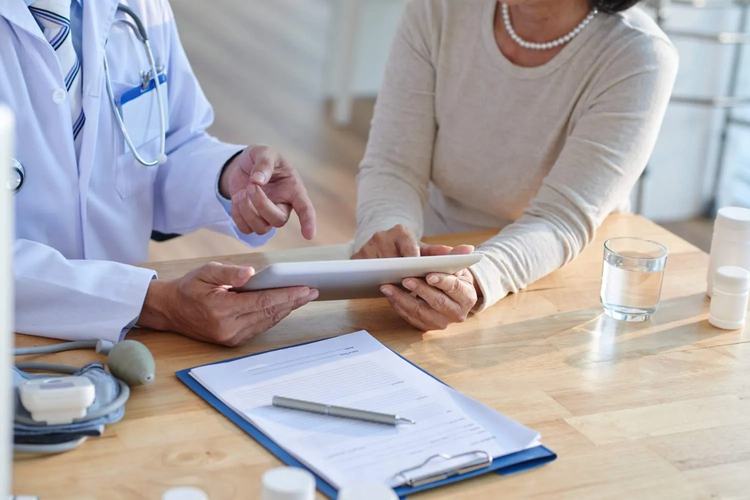 Doctor going over Medicare details on a tablet with an older woman